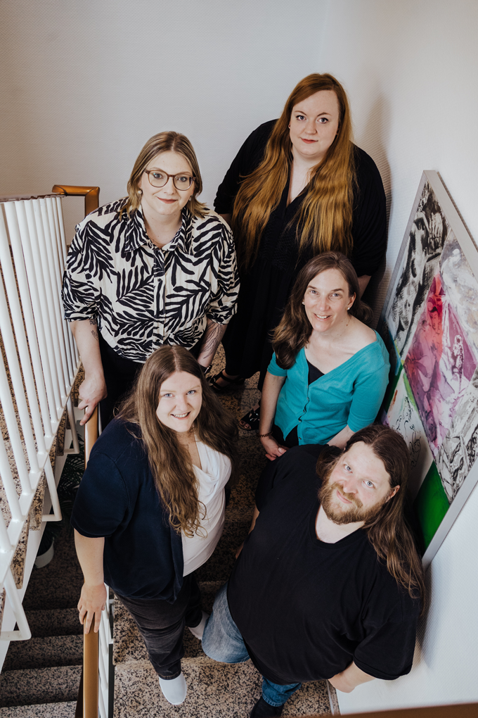 Hochkant-Foto mit dem Team von Kia Kahawa Verlagsdienstleistungen: Marcel, Anke, Kia, Christian und Bente stehen auf einer Treppe, Fotografie von oben.